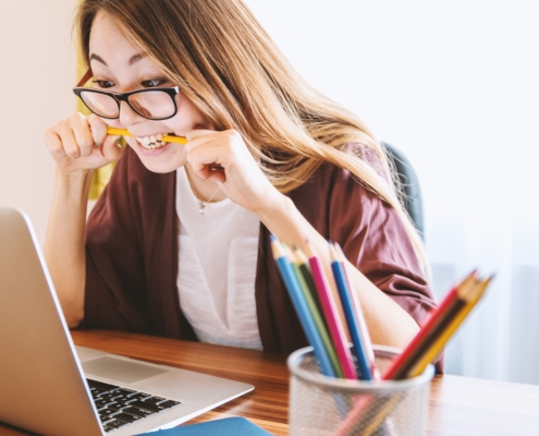 gestresste Abiturientin mit Stift im Mund am Schreibtisch - Christiane Witt - Feng Shui Beratung